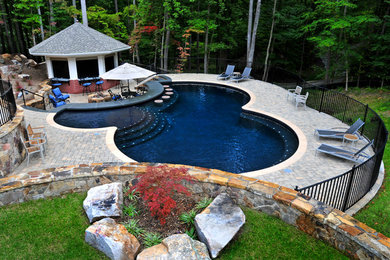 Ejemplo de casa de la piscina y piscina alargada tradicional renovada de tamaño medio a medida en patio trasero con adoquines de ladrillo