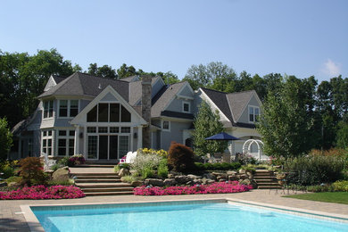 Example of a large classic backyard concrete paver and rectangular aboveground pool house design in Columbus