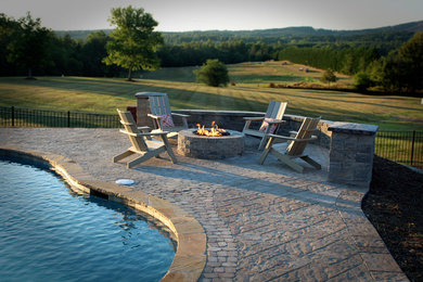 Pool - large backyard concrete paver and custom-shaped pool idea in Charlotte