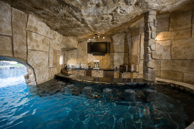 Cette image montre un très grand Abris de piscine et pool houses arrière traditionnel sur mesure avec des pavés en pierre naturelle.