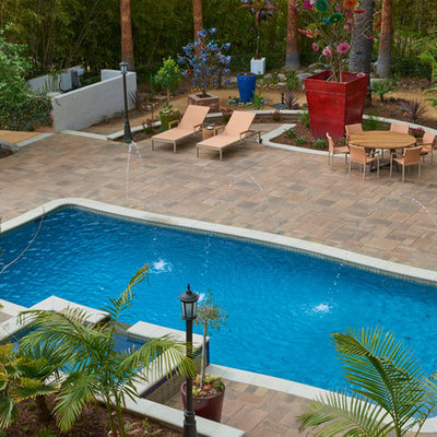 Hot tub - large tropical backyard brick and rectangular lap hot tub idea in Los Angeles