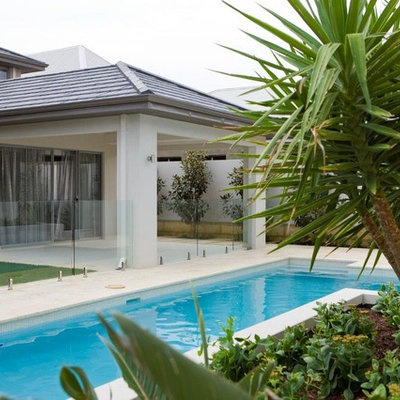 Mid-sized minimalist backyard stone and rectangular lap pool fountain photo in Perth