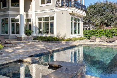 Diseño de piscinas y jacuzzis alargados contemporáneos grandes rectangulares en patio trasero con adoquines de piedra natural