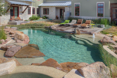 Imagen de piscina natural de estilo de casa de campo a medida con adoquines de piedra natural