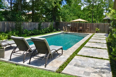 Imagen de piscina alargada contemporánea de tamaño medio rectangular en patio trasero con adoquines de piedra natural