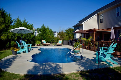 Diseño de piscina alargada marinera de tamaño medio a medida en patio trasero con losas de hormigón