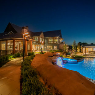 Immagine di un'ampia piscina naturale country personalizzata dietro casa con pavimentazioni in pietra naturale