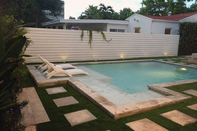 Diseño de piscina marinera de tamaño medio en forma de L en patio trasero con suelo de hormigón estampado