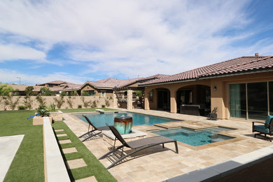 Example of a large tuscan backyard stone and rectangular lap pool fountain design in Las Vegas