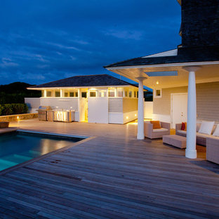 Immagine di un'ampia piscina minimal rettangolare dietro casa con pedane e una dépendance a bordo piscina