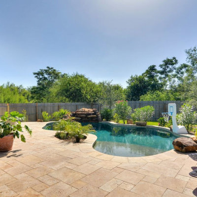 Pool fountain - mid-sized rustic backyard stone and custom-shaped natural pool fountain idea in Austin