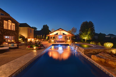 Example of a large classic backyard pool fountain design in Other