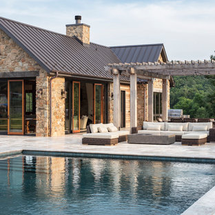 Foto di una grande piscina monocorsia country rettangolare dietro casa con una dépendance a bordo piscina e pavimentazioni in pietra naturale