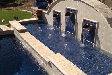 Foto de piscina tropical de tamaño medio rectangular en patio trasero con adoquines de piedra natural