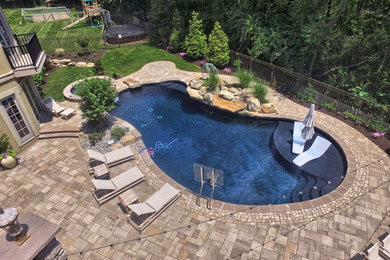 Inspiration for a large contemporary back kidney-shaped hot tub in Philadelphia with concrete paving.