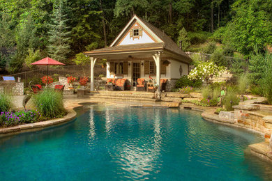 Inspiration för mellanstora amerikanska anpassad baddammar längs med huset, med poolhus och marksten i tegel