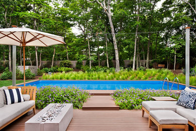 Transitional backyard rectangular lap pool photo in New York with decking