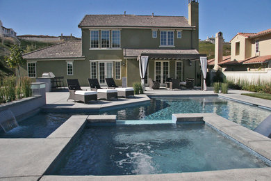 Imagen de piscinas y jacuzzis clásicos extra grandes a medida en patio trasero con adoquines de hormigón