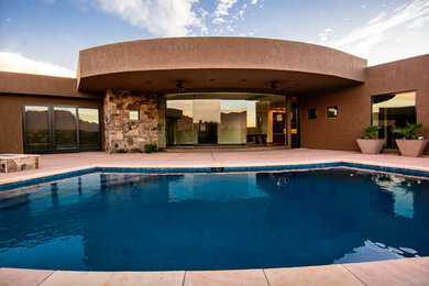 Ejemplo de piscinas y jacuzzis alargados de estilo americano grandes rectangulares en patio trasero con suelo de baldosas