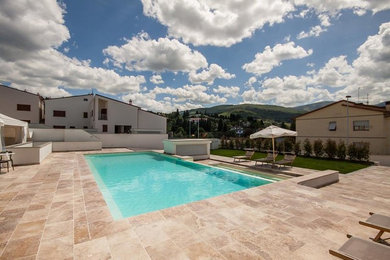 Ispirazione per una grande piscina fuori terra design personalizzata dietro casa con pavimentazioni in pietra naturale