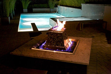 Modelo de piscina minimalista de tamaño medio rectangular en patio lateral con adoquines de hormigón