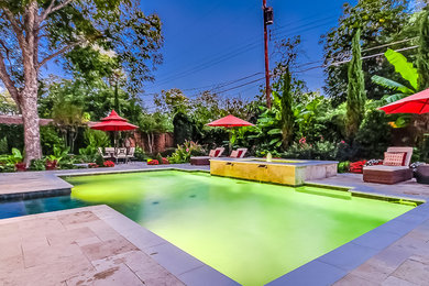 Hot tub - tropical courtyard stone and custom-shaped hot tub idea in Dallas