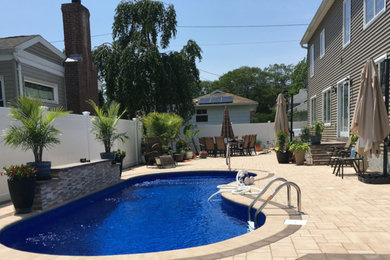 Idee per una piscina fuori terra tradizionale a "C" di medie dimensioni e dietro casa con piastrelle