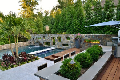 Foto de piscina exótica de tamaño medio en forma de L en patio trasero con suelo de baldosas