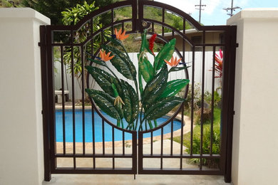 Ispirazione per una grande piscina monocorsia tropicale a "C" dietro casa con pavimentazioni in pietra naturale