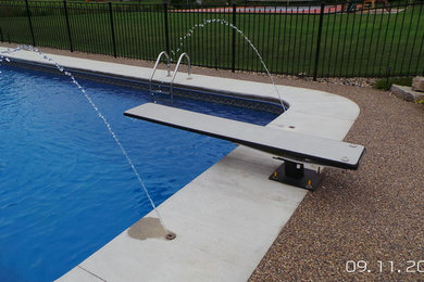 Inspiration for a large contemporary back l-shaped swimming pool in Detroit with concrete slabs.