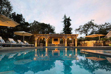 Diseño de piscinas y jacuzzis alargados clásicos grandes rectangulares en patio trasero con suelo de baldosas