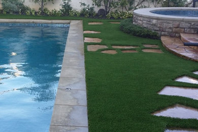 Ejemplo de piscinas y jacuzzis alargados minimalistas de tamaño medio rectangulares en patio trasero con adoquines de piedra natural