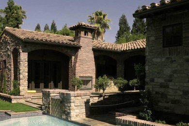 Example of a mid-sized tuscan backyard rectangular lap pool fountain design in Other