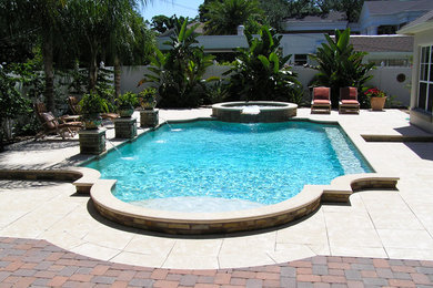 Foto di una piscina mediterranea personalizzata di medie dimensioni e dietro casa con pavimentazioni in cemento e una vasca idromassaggio