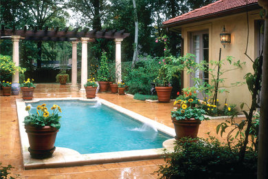Ispirazione per una grande piscina naturale mediterranea rettangolare in cortile con pavimentazioni in pietra naturale e fontane