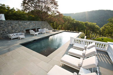 Ejemplo de piscinas y jacuzzis alargados de estilo americano grandes rectangulares en patio lateral con adoquines de piedra natural