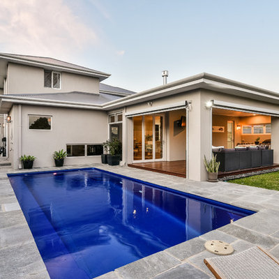 Example of a mid-sized minimalist backyard stone and rectangular lap pool design in Perth