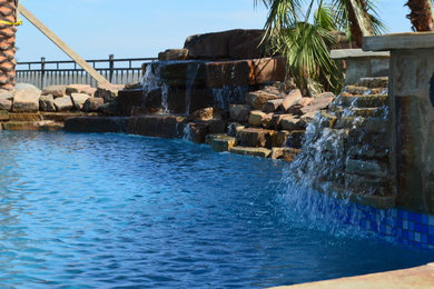 Example of a mountain style backyard natural pool design in Austin