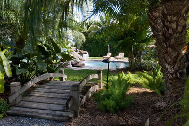 マイアミにあるお手頃価格の中くらいなトロピカルスタイルのおしゃれなプール (噴水、コンクリート敷き	) の写真
