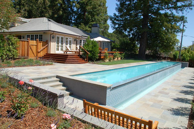 Example of a mid-sized trendy backyard stone and rectangular infinity pool design in San Francisco