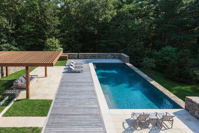 Inspiration for a mid-sized contemporary backyard rectangular lap pool remodel in Montreal with decking