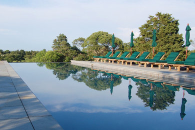 Modelo de piscina infinita minimalista grande rectangular con adoquines de piedra natural y paisajismo de piscina