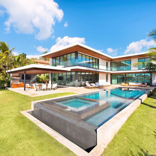 Großer Moderner Pool hinter dem Haus in rechteckiger Form mit Betonplatten in Miami