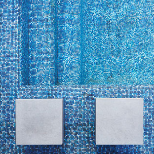 Ispirazione per una piscina a sfioro infinito design rettangolare di medie dimensioni e in cortile con pedane e una dépendance a bordo piscina