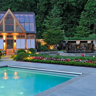 Diseño de piscina actual, grande, rectangular, en patio trasero, con adoquines de hormigón