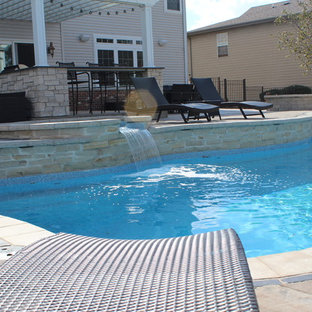 Inspiration for a large contemporary backyard custom-shaped lap pool in Chicago with a hot tub and brick pavers.