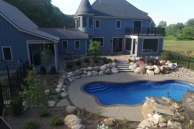Идея дизайна: бассейн среднего размера, произвольной формы на заднем дворе в викторианском стиле с покрытием из бетонных плит