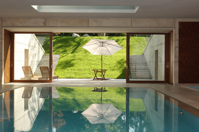 Diseño de piscina contemporánea grande rectangular y interior con suelo de baldosas