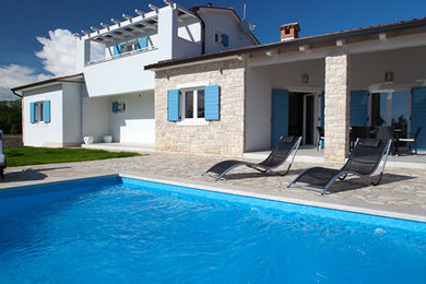 Imagen de casa de la piscina y piscina mediterránea pequeña en patio delantero con suelo de baldosas