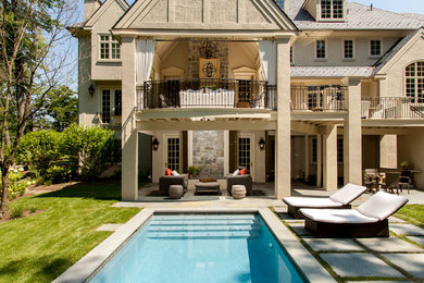 Modelo de piscina alargada clásica extra grande rectangular en patio trasero con adoquines de piedra natural